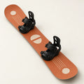 Burnt-orange Freestyle 154 snowboard with cream geometric graphics and black bindings, shown at a three-quarter angle